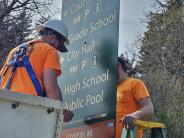 Public works crew installing wayfinding signs