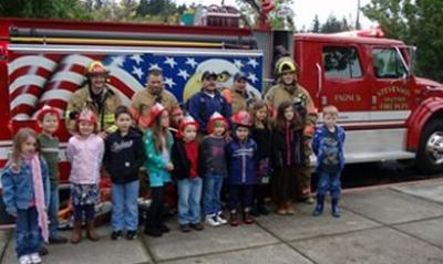 Kids taking pictures with firemen